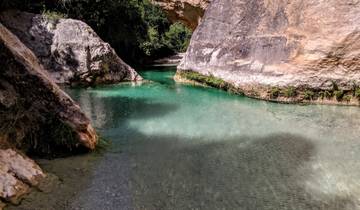 A scenic river with clear water flowing between rock formations.