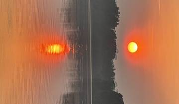 Sunset view over a river with reflections on the water.