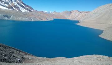 Pristine blue mountain lake surrounded by rugged terrain.