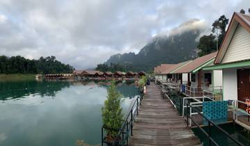 Row of lakefront bungalows in a serene mountainous setting.