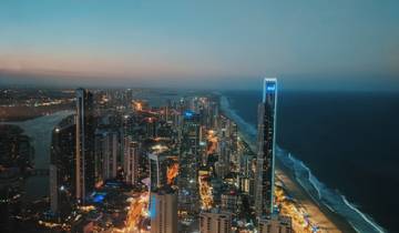 City skyline with tall buildings at dusk by the ocean