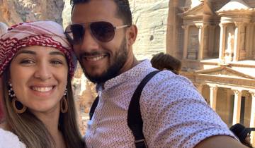 A couple smiling with the Treasury of Petra in the background.