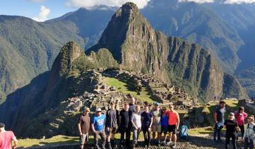 A group of people posing in front of Machu Picchu.