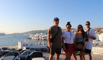 A group of people posing with a seaside town in the background.