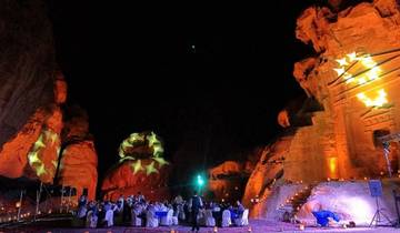 Dinner event with stars projected on rocky outcrops.