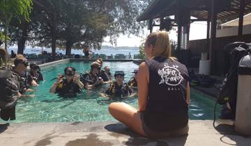 Group of people in a pool with diving gear.