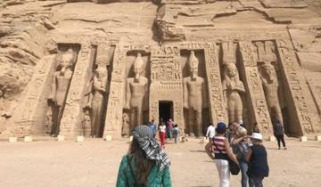 Tourists exploring ancient rock carvings and statues.