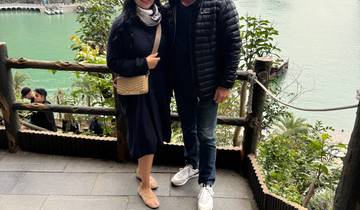 Two people posing with a scenic view of the ocean.