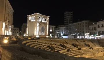 An illuminated amphitheater and historical architecture at night