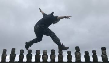 Man balancing creatively on Moai statues.