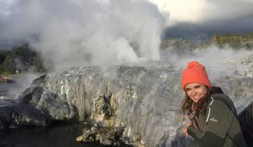 Woman posing near steaming geothermal activity.