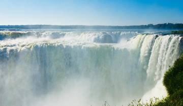 A powerful waterfall with mist rising up from the base.