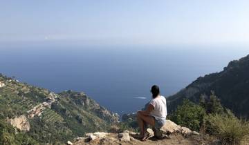 Person seated looking over vast sea landscape.
