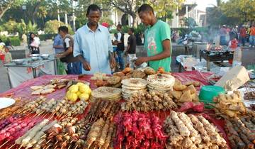Street food vendors at a market with various grilled items.