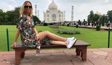 Woman sitting on a bench with the Taj Mahal in the background.
