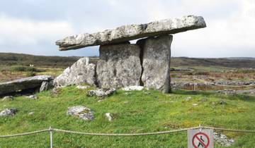 Ancient stone dolmen structure on a grassy field.