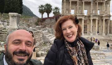 Two people smiling in front of ancient ruins.