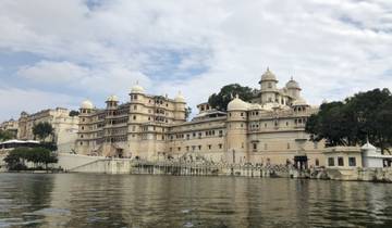 A grand palace overlooking a lake with multiple domes and towers.