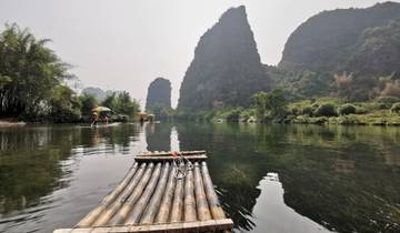 Bamboo raft on a river with karst mountains in the background.