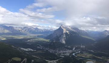 Panoramic view of a valley with mountains and a river.