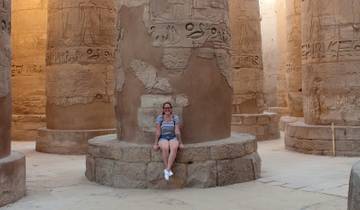 A person sitting on a column base in an ancient temple.
