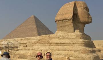 Two people in front of the Sphinx and a pyramid.