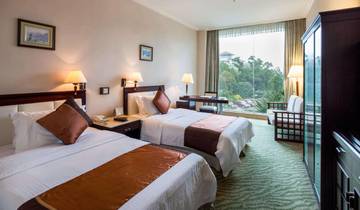 Hotel room with two beds and a large window view.