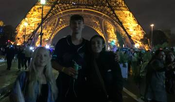 Group in front of an illuminated structure at night.