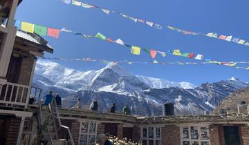 View from a mountain village with people on a rooftop.