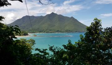 Coastal view with turquoise water and mountain backdrop.