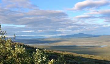 Scenic landscape of mountains and valleys under a partly cloudy sky.