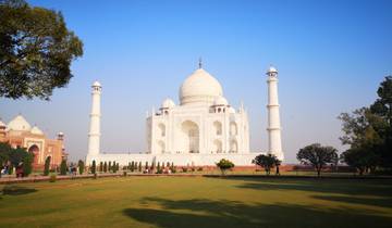 The Taj Mahal viewed from across the garden, with people in the foreground.