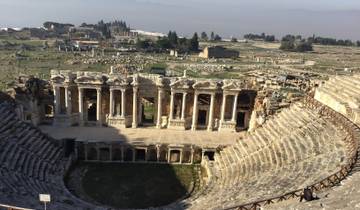 Ancient ruins with a large amphitheater in the foreground.