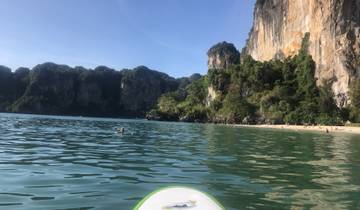 A beach with clear waters and majestic cliffs.