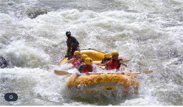 Group of people rafting on a river with crashing waves.