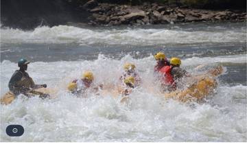 People white-water rafting on a river with rapids.