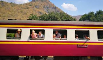 Group of people leaning out of a colorful train window.