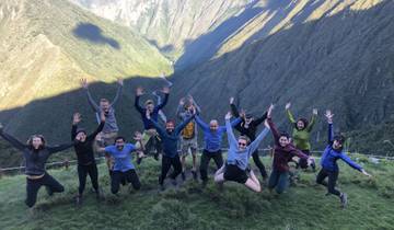 Group of people jumping with joy in a mountainous landscape.