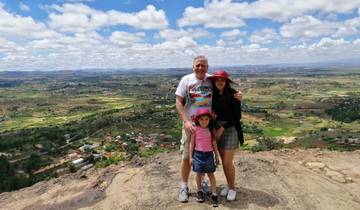 A family posing at a viewpoint with a vast landscape of fields and scattered houses.