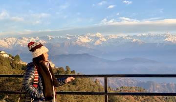 Person enjoying a mountain view with snow-covered peaks.