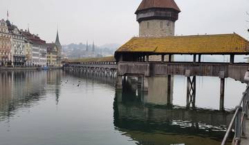 Historic wooden covered bridge over a calm river.