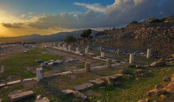 Ruins at sunset with a hilly backdrop.