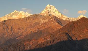 Sunlit mountain peaks with clear sky backdrop.