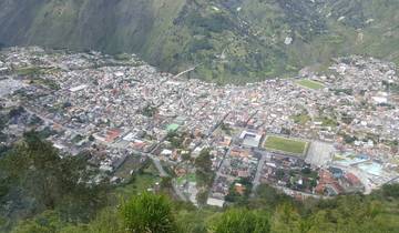 Aerial view of a city nestled in a valley surrounded by mountains.