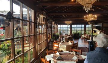 Inside a cozy restaurant with chandeliers and wooden tables.