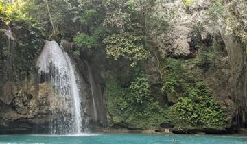 Waterfall flowing into a turquoise pool surrounded by forest.