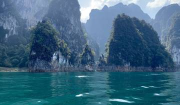 Majestic limestone cliffs rising from clear blue sea.