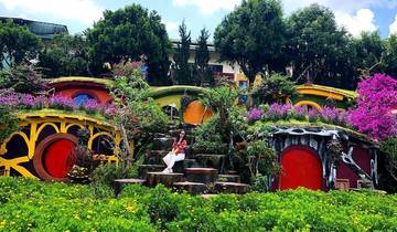 Colorful Hobbiton-themed park with flowers and doors.