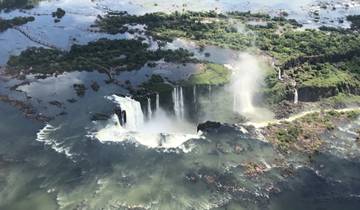 Aerial view of Iguazu Falls surrounded by lush greenery.