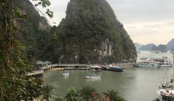View of limestone karsts and boats in a bay.